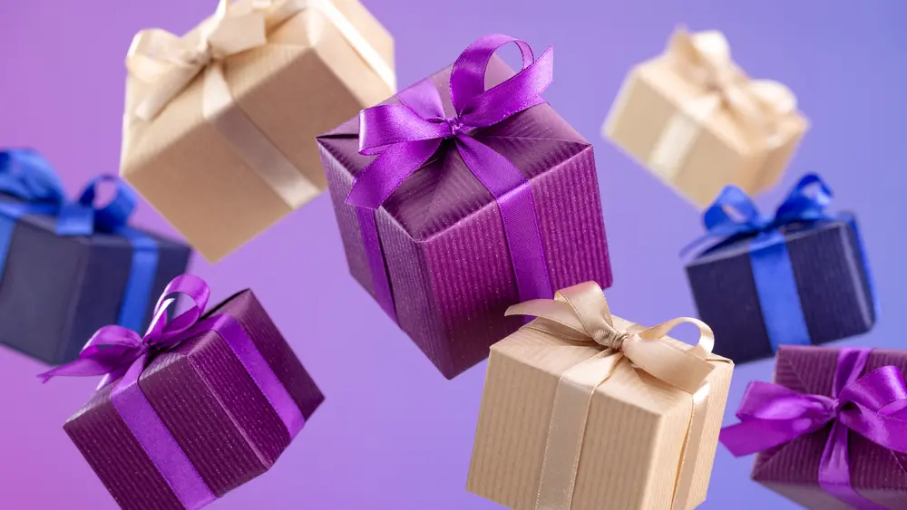 Gifts in flying boxes, wrapped in blue, purple and kraft paper with bow on lilac background. Sale, discounts.