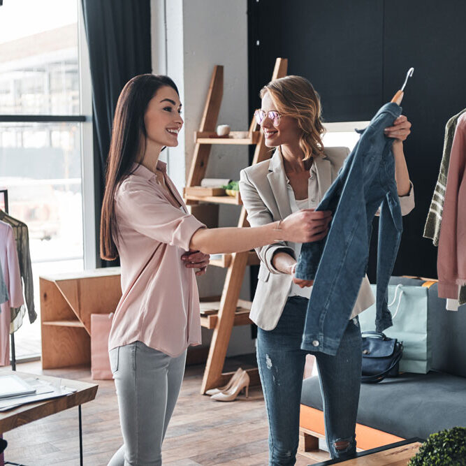 shopping concept with 2 women looking at a denim jacket